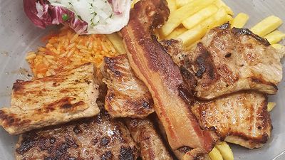 Ein Teller mit Fleisch, Pommes und Reis