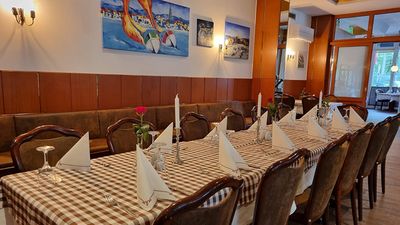 Ein gedeckter Tisch mit roten Blumen drauf